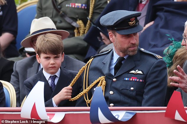 Louis also tugged on his father's uniform as the pair sat in the front row of the specially made dias at Buckingham Palace