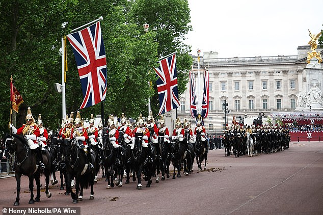 Members of the Household Cavalry, Life Guards front, followed by the Blues and Royals, ride along The Mall this morning