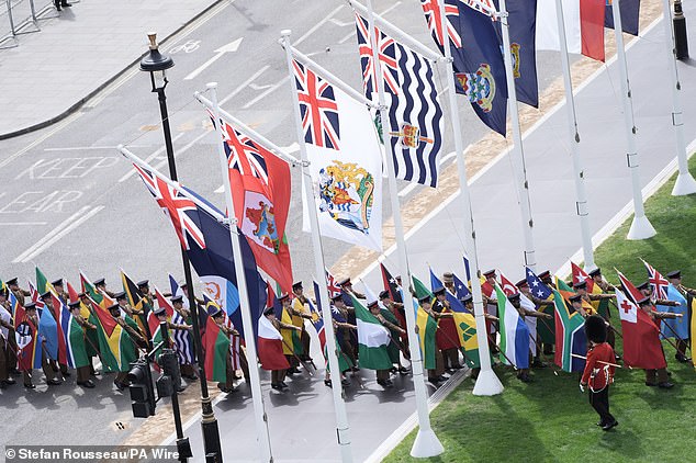 The flags of Commonwealth countries are brought into Parliament Square ahead of the military procession today