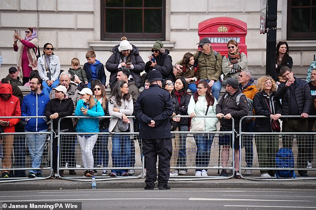 Members of the public wait near Parliament Square in London today ahead of a procession for the 80th anniversary of VE Day