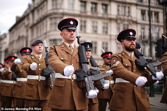 Members of the military march past Parliament Square in London this morning to mark the 80th anniversary of VE Day