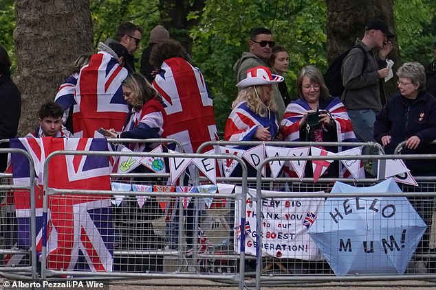 Members of the public draped in flags ahead of a military procession marking the 80th anniversary of VE Day in London today