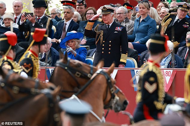 Britain's King Charles salutes next to Queen Camilla during the armed forces and veterans' parade for VE Day 80 today