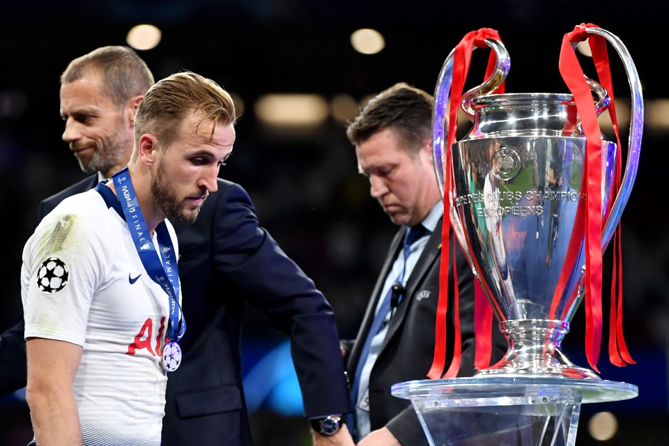 Harry Kane of Tottenham Hotspur walks past the UEFA Champions League trophy after the final match.