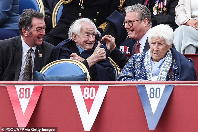 Mr Keir animatedly talks to the Prime Minister from their prime position outside Buckingham Palace