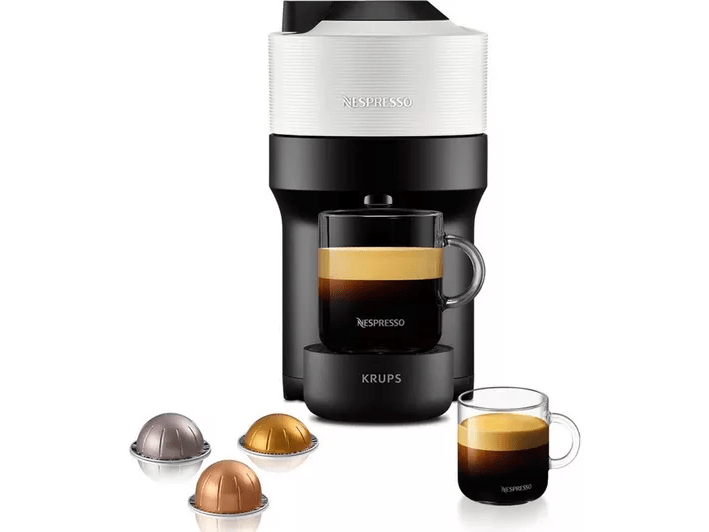 Nespresso Krups coffee machine with coffee pods and cups.