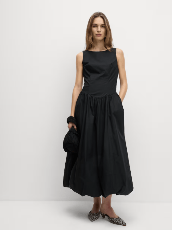 Model wearing a black midi dress and shoes.