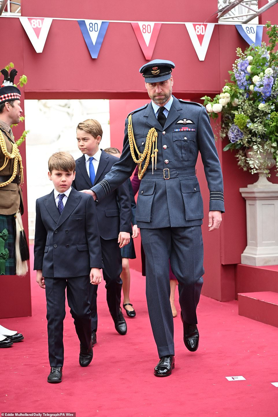 Louis walked next to his father, sporting a  smart suit, as he joined his family for today's celebrations