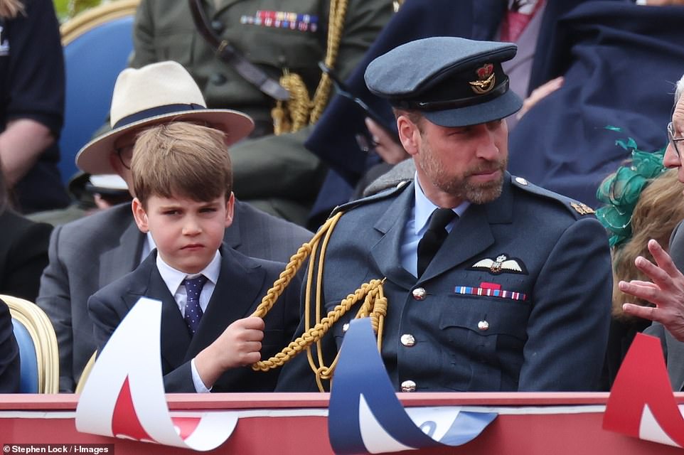 Louis also tugged on his father's uniform as the pair sat in the front row of the specially made dias at Buckingham Palace