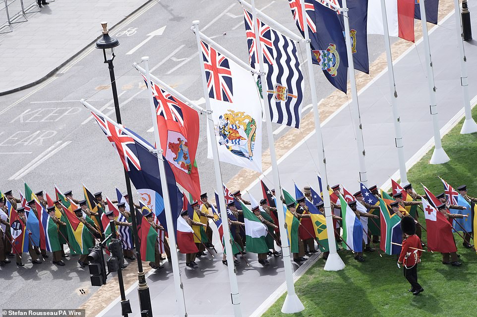 The flags of Commonwealth countries are brought into Parliament Square ahead of the military procession today