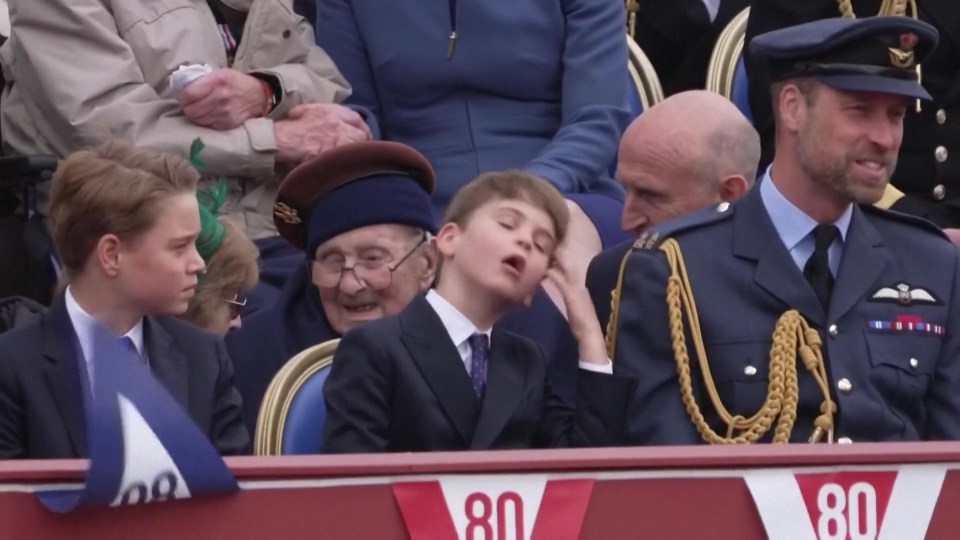 A boy yawning at a formal event, seated next to an elderly woman and a man in military uniform.
