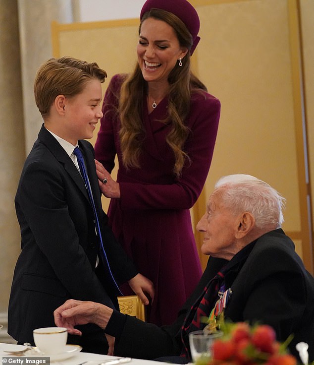 Dressed in a smart suit with a blue tie, William and Kate's eldest son beamed as he posed for photos with attendees and joined in conversation with guests