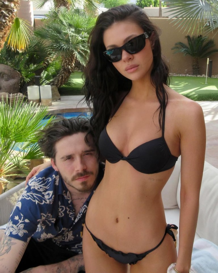 Woman in a bikini with a man in a floral shirt.