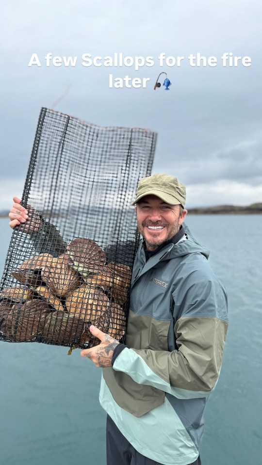 Man holding a net full of scallops after a fishing trip.