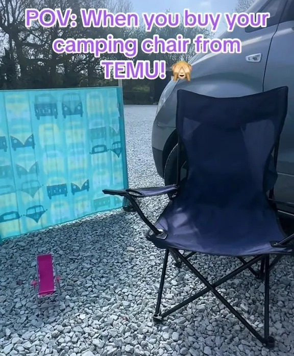 Small, inexpensive camping chair on gravel next to a windbreak.