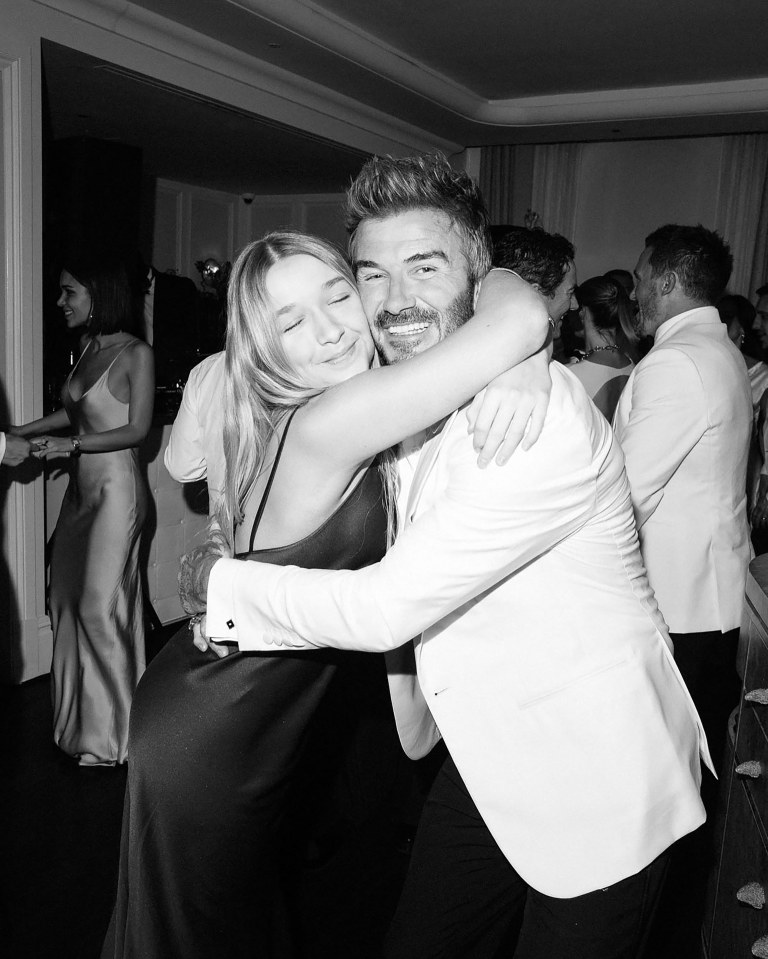 Black and white photo of David Beckham embracing his daughter at a party.