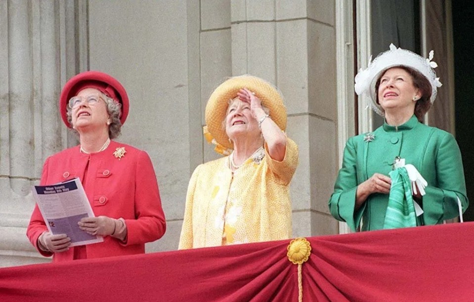 Queen Elizabeth II, the Queen Mother, and Princess Margaret watching a flypast at Buckingham Palace.