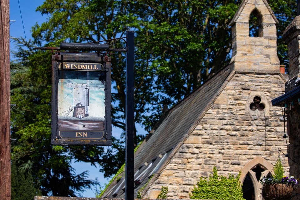 Windmill Inn pub sign with windmill illustration.