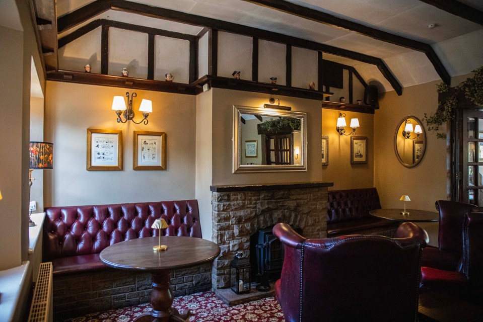 Interior of a traditional pub with a fireplace and leather seating.