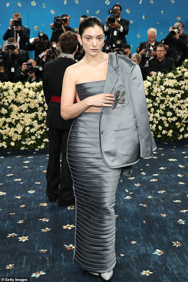 Lorde seemed to match the rainy day in New York City as she wore an understated, gray satin two-piece by Thom Browne. She draped a matching satin blazer over her shoulders in an effort to appear casual
