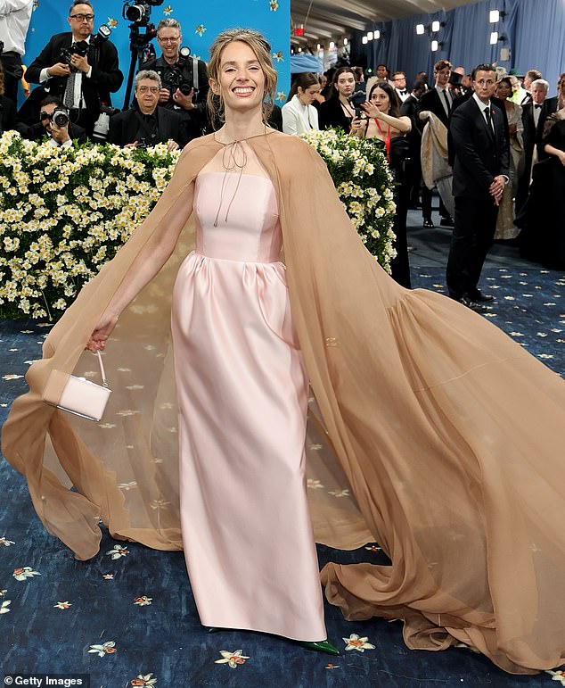 Mismatched! Actress Maya Hawke wore a strapless, silky pink dress by Prada with a corset top and a long brown cape over the top. The tie on the front of the cape looked sloppy as she walked down the carpet