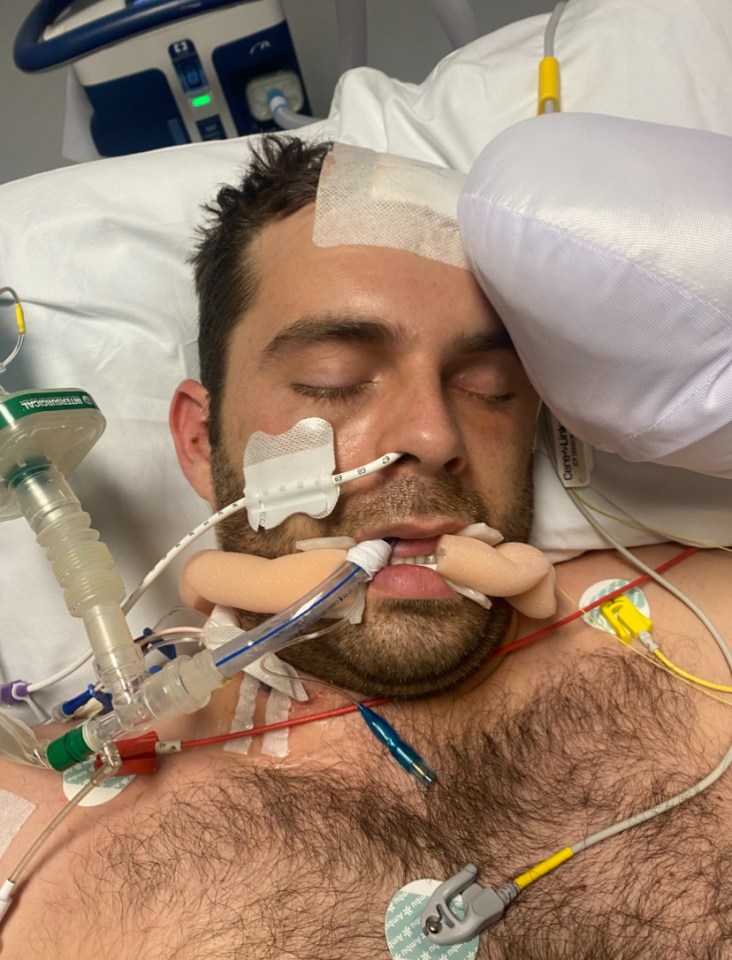 Man in hospital bed with medical equipment attached.