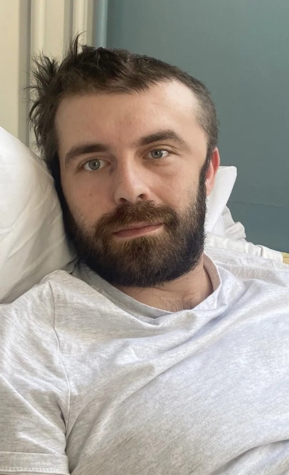 Man with beard lying in bed.