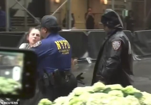 In shocking footage, a woman wearing a grey sweatsuit screams at security as she tries to enter one of the entrances to the hotel