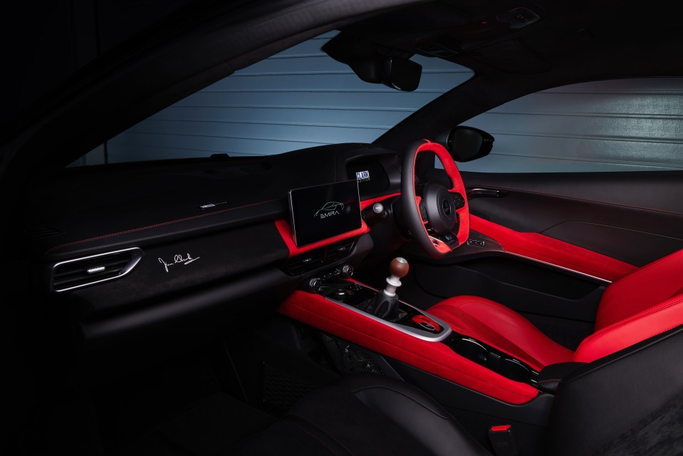 Interior view of the Lotus Emira Clark Edition, featuring red and black leather seats and Jim Clark's signature.