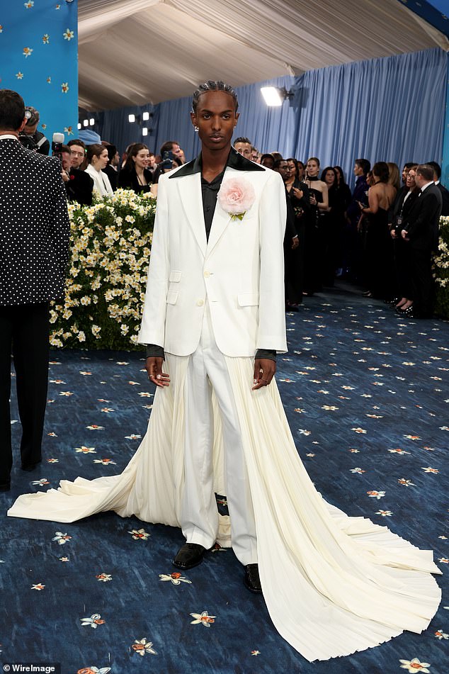 Christian Latchman donned a white suit with a cream colored cape and a black shirt