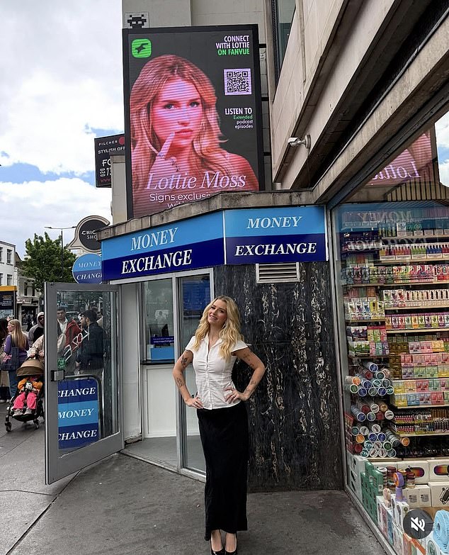 Lottie Moss has shared this photograph online of her posing beneath a billboard displaying her image in an advertisement for Fanvue