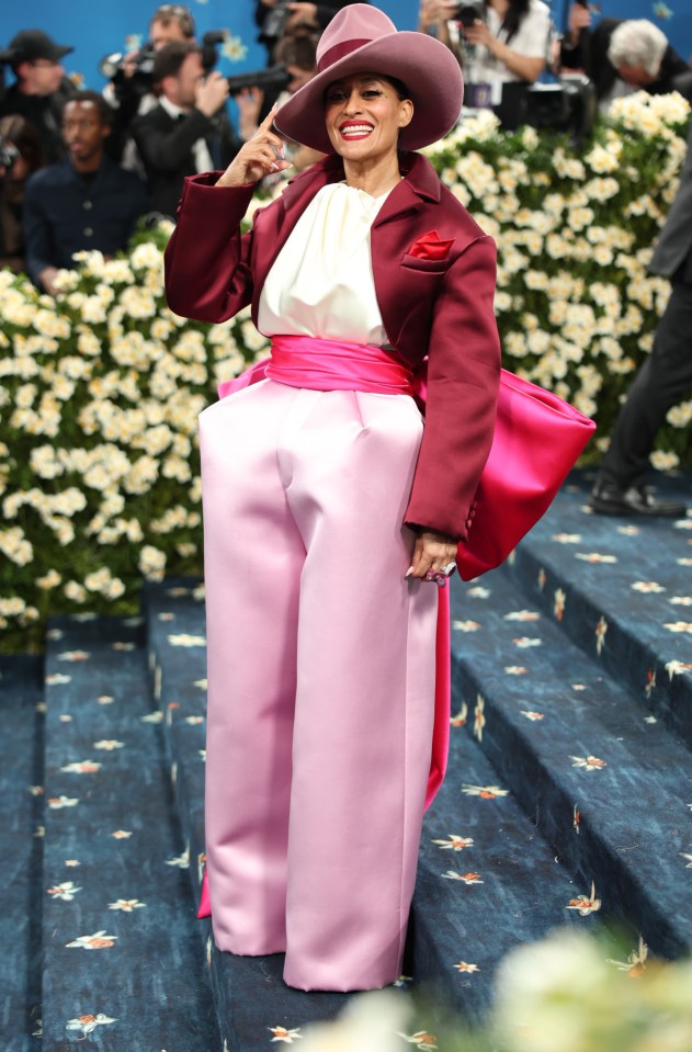 Tracee Ellis Ross at the Met Gala in a pink pantsuit and burgundy jacket.
