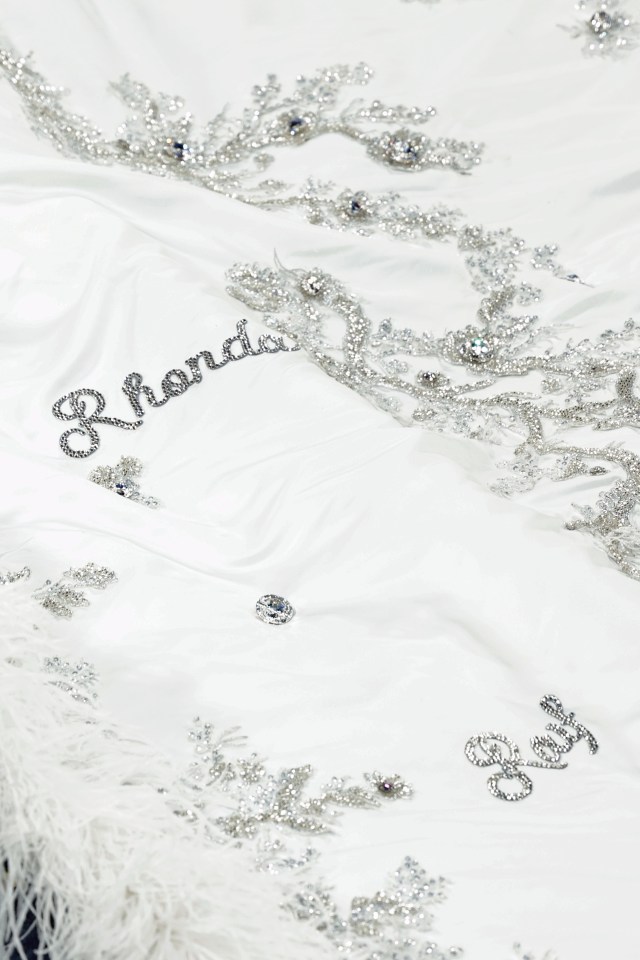 Close-up of a white garment embellished with silver beading and the name "Rhonda" spelled out in rhinestones.