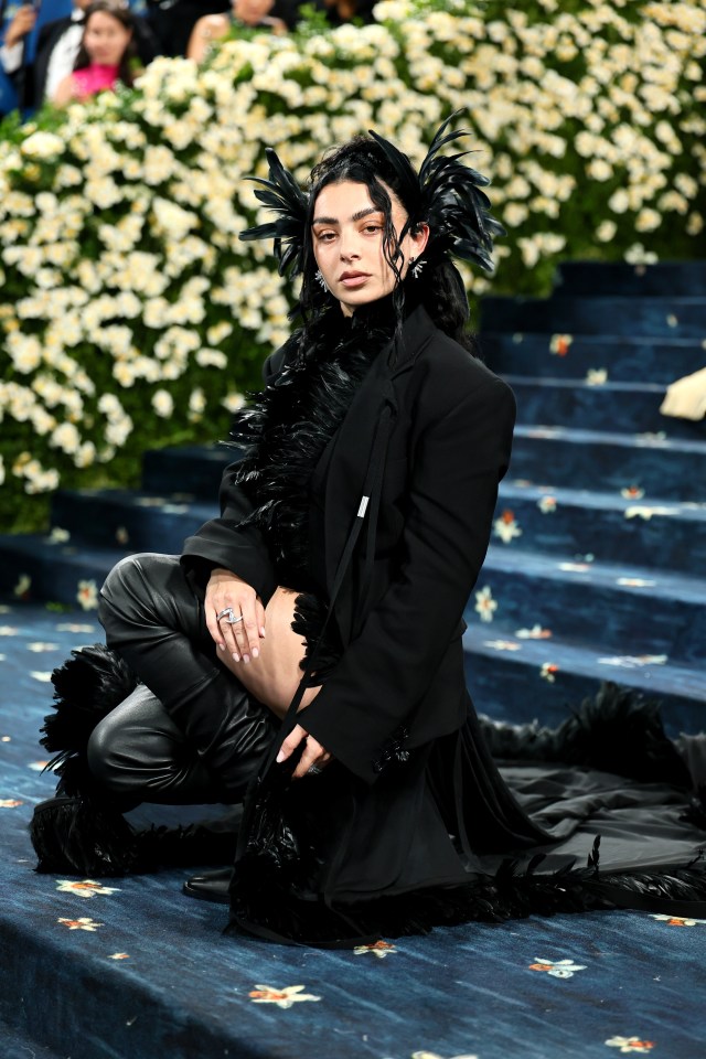 Charli XCX at the Met Gala in a black feather outfit.