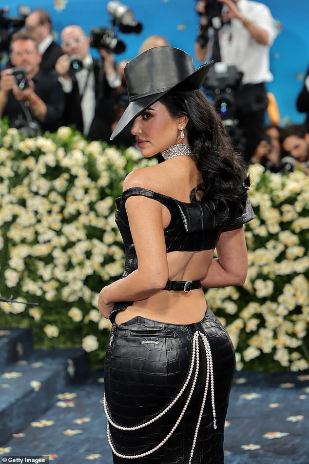 Kim accessorized with several diamond necklaces which cascaded down her chest along with matching dangling earrings