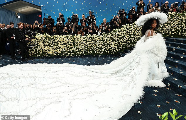 Ross hit fashion's biggest night in a low-cut, floor-length, crystal-covered gown topped by a larger-than-life white cape with feather trim