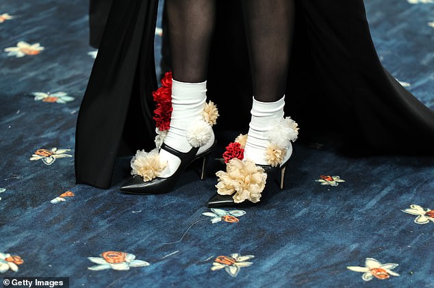 She added a splash of color with red, white and cream-colored carnations decorating her black shoes