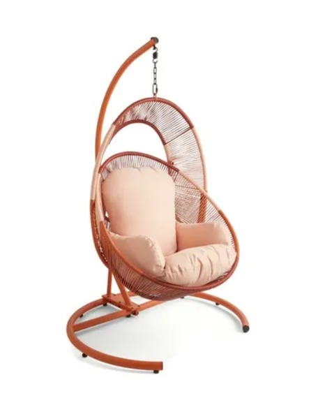 Hanging wicker chair with pink cushion.