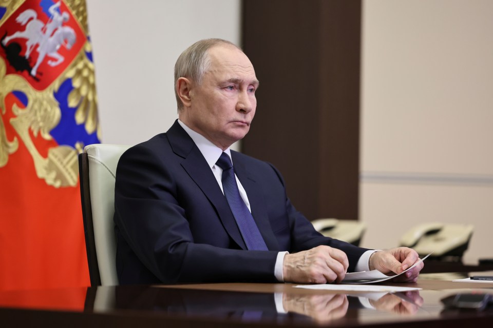 Vladimir Putin listening during a meeting.