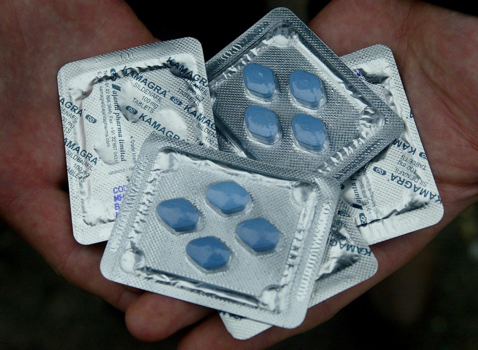 Hand holding Kamagra tablets.