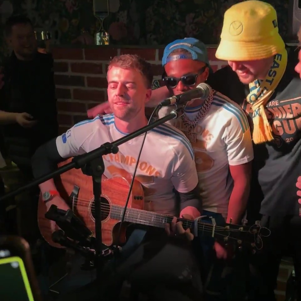 Leeds United players singing and playing guitar.