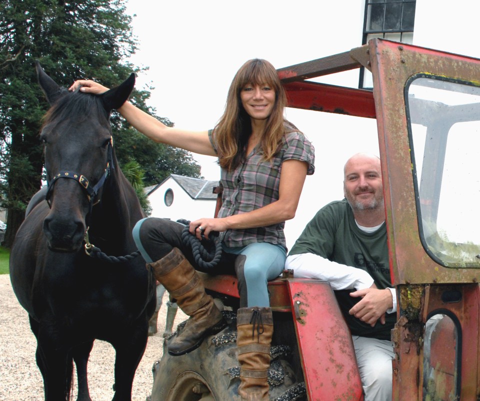 Woman and man sitting on a tractor with a horse.