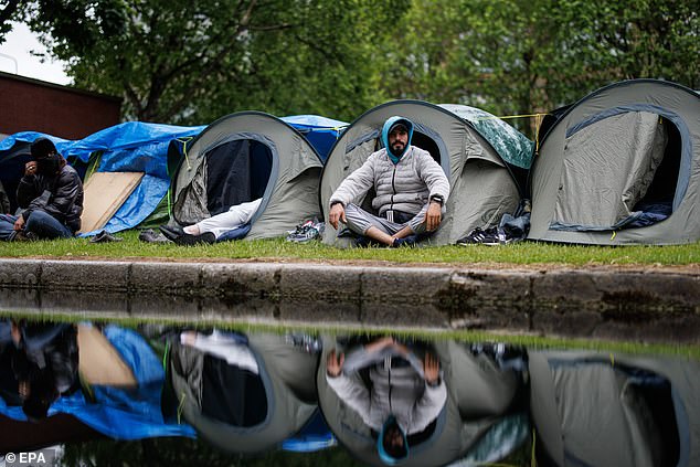 A migrant sits in his tent at a makeshift camp where homeless asylum seekers sleep rough in tents along Grand Canal in Dublin, Ireland, 22 May 2024
