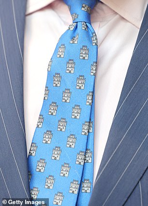 The King opted for a fun castle-themed patterned tie and a smart navy pinstriped suit for the outing