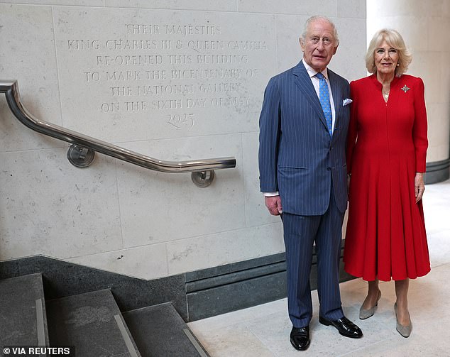 The King and Queen pose next to a sign marking their visit to the National Gallery today
