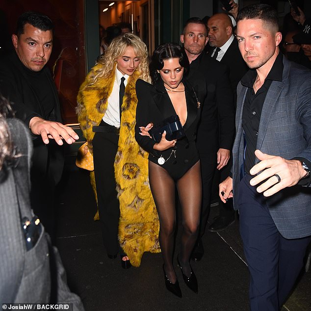 Sabrina, 25, ensured she stood out by wearing a floor length, canary yellow coat over a smart black trouser-suit as they emerged flanked by security guards