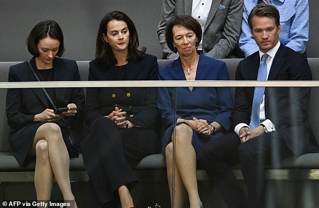 Charlotte Merz (2ndR), the wife of designated German Chancellor Friedrich Merz and her daughters Carola Cluesener (2ndL) and Constanze Merz (L) watch the session before leaving immediately after the vote results