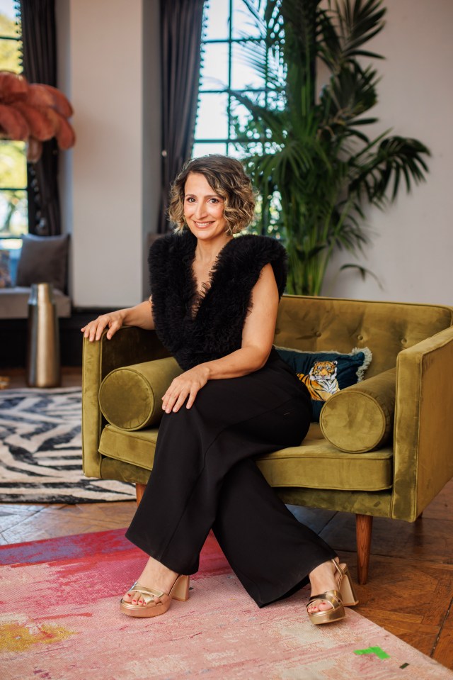 Woman in black outfit sitting on a green chair.