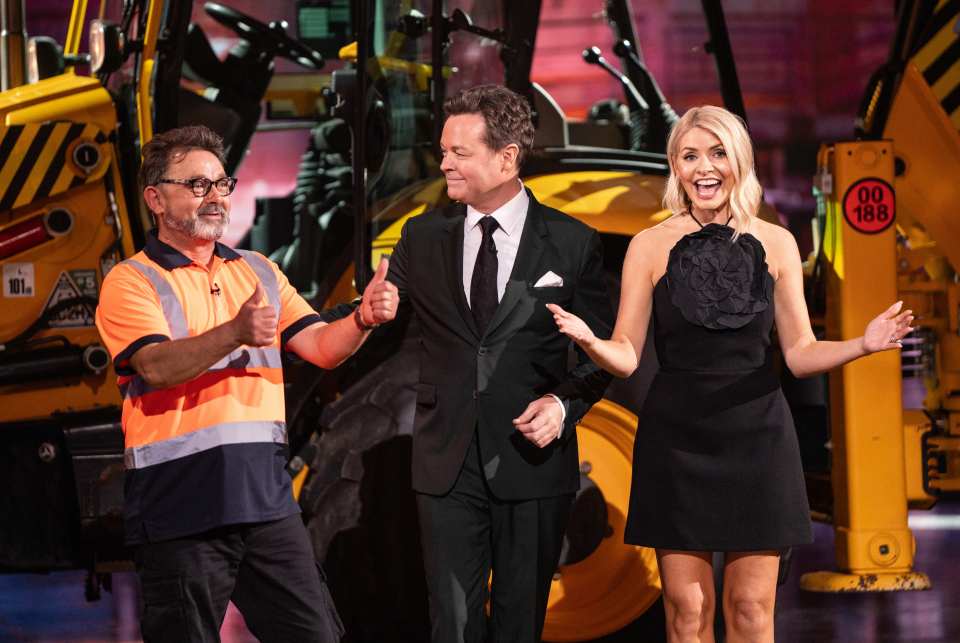 Holly Willoughby and Stephen Mulhern on set with a man in a high-visibility vest.