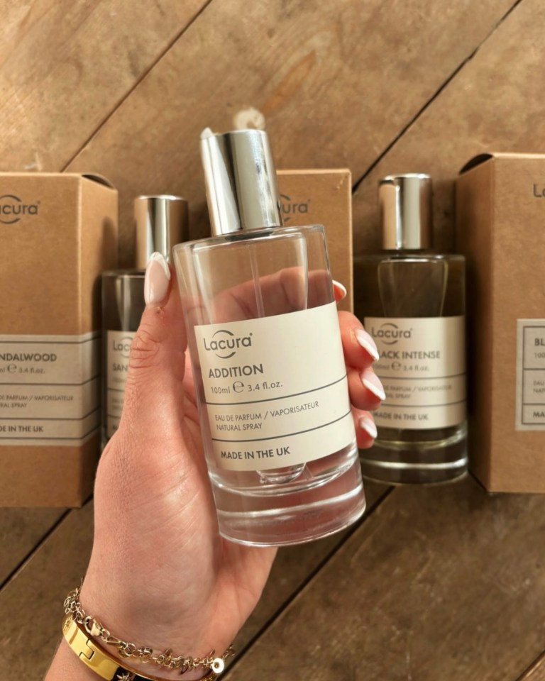 Hand holding Lacura Addition perfume.